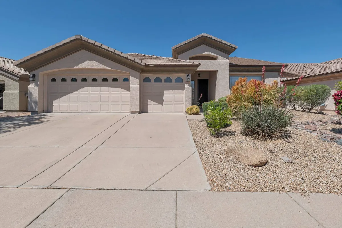 This exterior image displays the home's front entrance, garage doors, and a landscaped area. The scene radiates a welcoming, sunlit vibe that hints at outdoor fun and group activities such as barbecues or gatherings.